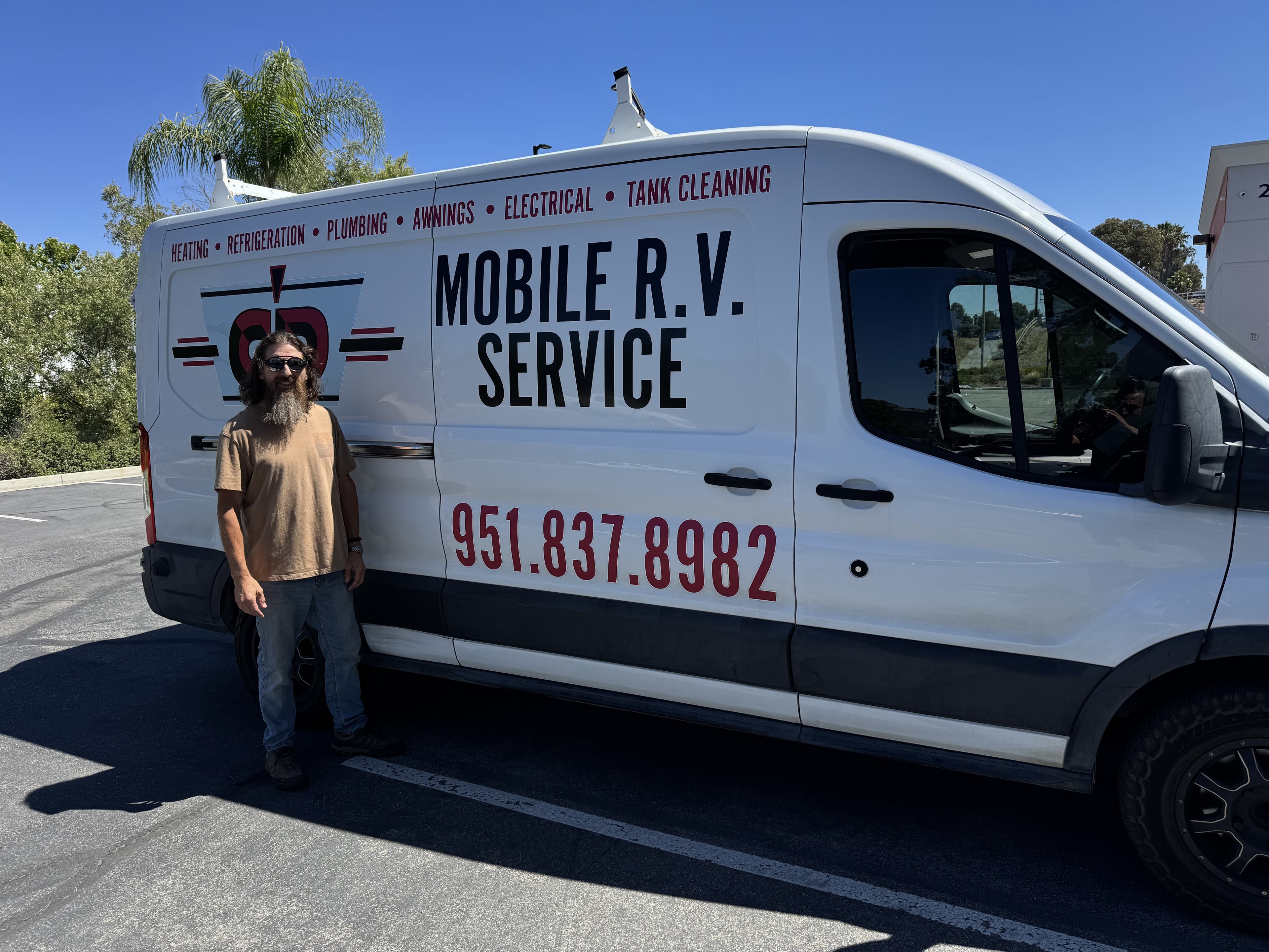 Owner standing in front of his work van